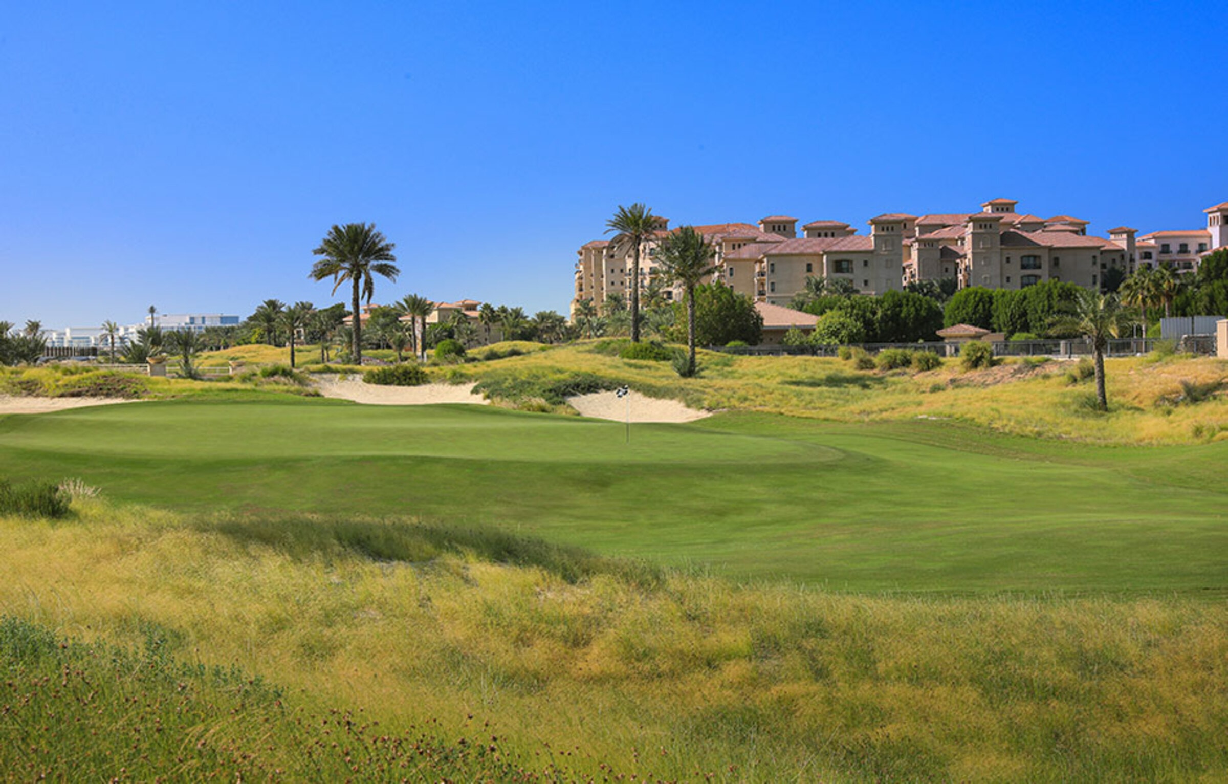Surroundings: a fairway at Saadiyat Beach Golf Club with the Saadiyat Beach resort buildings behind
